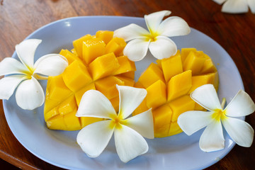 Fototapeta na wymiar sliced beautiful mango and frangipani flowers