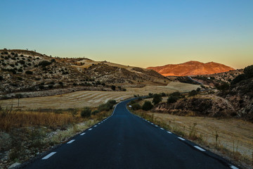 road in mountains while sunset