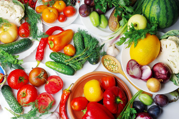 Appetizing vegetables in plates on the table. Cabbage, eggplants, tomatoes, cucumbers, peppers, parsley.