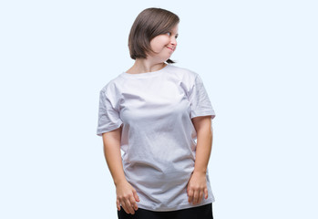 Fototapeta premium Young adult woman with down syndrome over isolated background looking away to side with smile on face, natural expression. Laughing confident.
