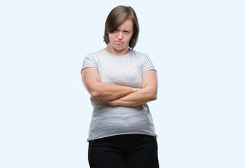 Young adult woman with down syndrome over isolated background skeptic and nervous, disapproving...