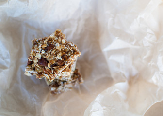 Healthy bars with almonds, oats and dates fruits on kraft background, with copy space.