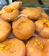 Traditional Indian ladoos, laddus, delicious sweet fried pastries with spices and saffron, Asian dessert, Indian sweets