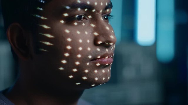 Handsome Young Indian Man is Identified by Biometric Facial Recognition Scanning Process. Futuristic Concept: Projector Identifies Individual by Illuminating Face by Dots and Scanning with Laser