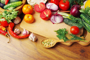 Vegetables on the kitchen board. Tomatoes, cucumbers, onions, garlic, pepper, parsley.