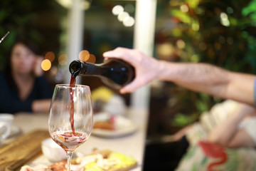 Person pouring red wine