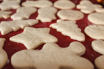 Perspective View of Warm Sweet Christmas Holiday Cut Out Sugar Cookies with White Flour on Bright Red Background