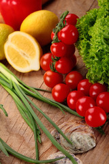 Cherry tomatoes , green onion, lemon leaf of salad on a wooden surface.Fresh vegetables