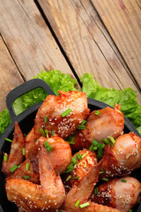 Roasted chicken legs on the wooden table . With green onion and salad.Copy space.