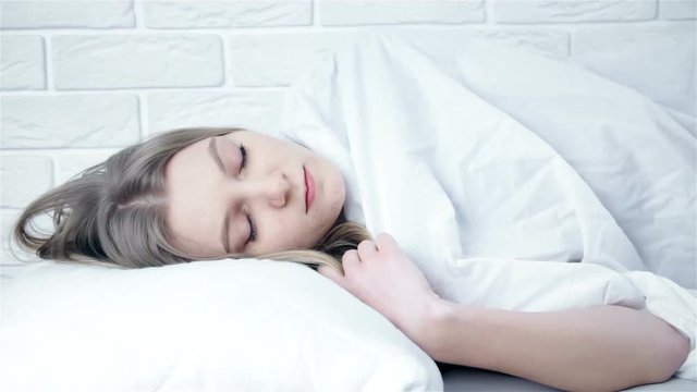 Shocked astonished pretty young woman wake up late in white bed