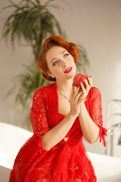beautiful pin up girl with red hair posing in a sexy lace robe in her bathroom