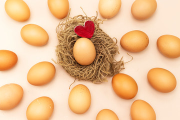 organic egg and wooden red heart isolated on pink background