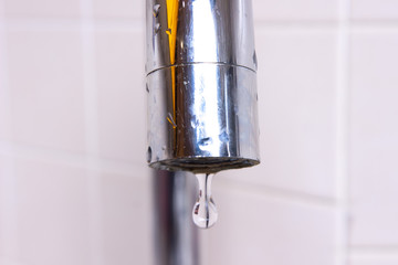 Faucet with water drop close-up.