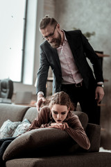 Fototapeta premium Businessman coming home and seeing daughter feeling depressed