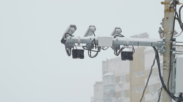 three security cameras on a lamppost.