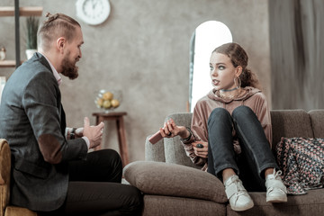 Teenager with makeup having emotional talk with counselor