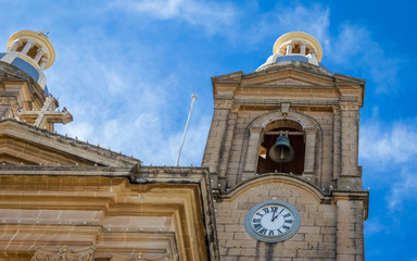 Detail view on St. Mary's Parish Church in Dingli. Old, historic and authentic christian chapel with nice blue couple and tower clock. Dingli, Malta. Europe