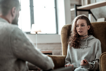 Teenage girl feeling involved in conversation with psychologist
