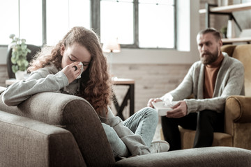 Girl crying while speaking about family problems to therapist