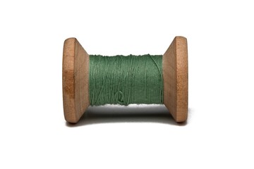 Wooden coil with thread on a white isolated background