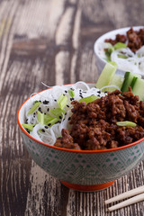 Asian style bowl with ground beef, rice noodles, cucumber, green onions and sesame seeds