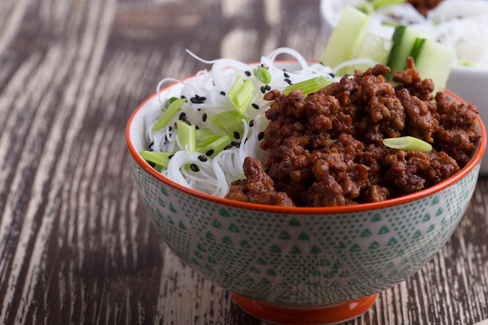 Asian style bowl with ground beef, rice noodles, cucumber, green onions and sesame seeds