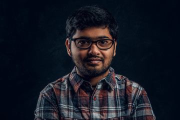 Obraz premium Portrait of a dark skinned chubby guy looking into a camera in a studio on a black background