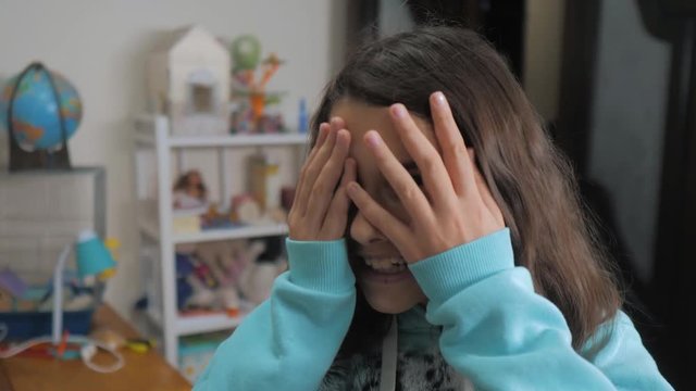 peek a boo. little girl covered her eyes face with her hands hide-and-seek waiting for a surprise. slow motion video. teen girl playing bo-peep lifestyle . childhood concept game hy - spy