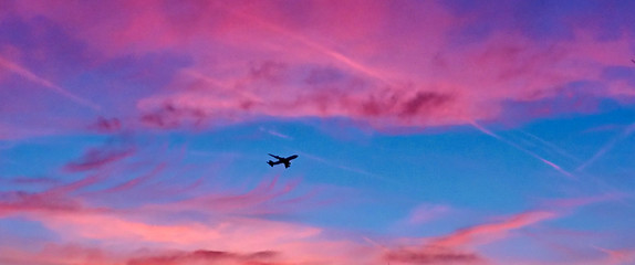 Flugzeug im Abendrot mit rosa Himmel