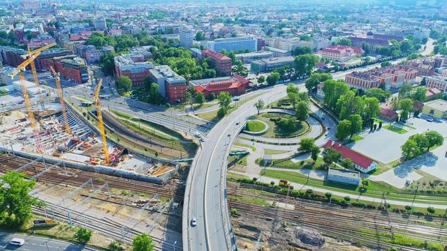 Panorama of Krakow city with a multi-level intersection, railroad tracks and cranes at the construction of a skyscraper. Aerial view from drone, from above