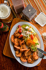 breaded shrimp platter with rice, salad and a beer