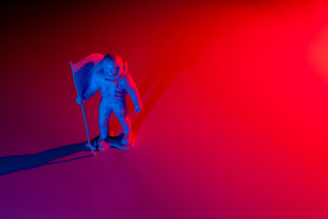 Lone Generic White Astronaut Figurine with American Flag in dramatic lighting