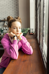 Dark-haired teenage girl feeling lonely staying at home alone
