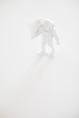 Lone Generic White Astronaut Figurine with American Flag in dramatic lighting