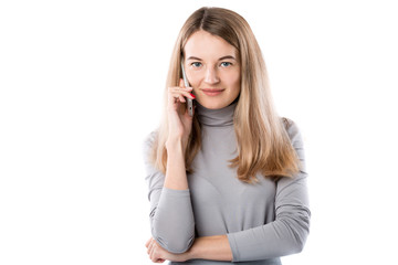 The theme of a business woman and telephone conversations. Beautiful young caucasian woman uses a smartphone handset to call in formal clothes on a white isolate background