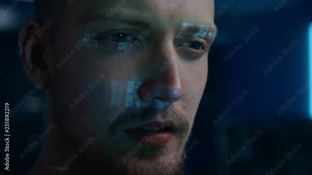 Poster Portrait of Software Developer / Hacker Working on Computer, Projected Code Numbers and Characters Reflect on His Face. Dark Room Full of Electronics, Computers, Displays. Hacking Programming Concept