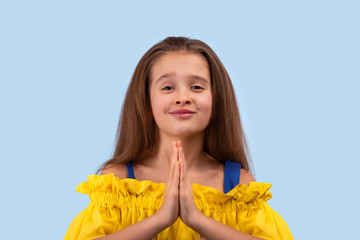 Close up emotional portrait of young blonde   girl wearing yellow sundress   on blue background in...