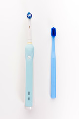 Manual Regular Toothbrush Against Modern Electric Toothbrush. Isolated on White Background