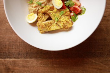Chicken curry with salad in the plate, top view