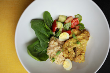 Plate with chicken curry and salad, top view