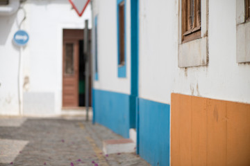 Fototapeta na wymiar Blue and orange exterior walls in Tavira. Colorful houses in Algarve, Portugal