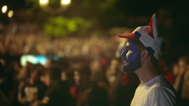 Closeup Russian fan lost bet on sport, very angry with game team. Guy with paint on face lost lot money, took head from terrible match. People angrily look losing their team bet on it. Loss money 4k.