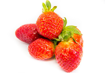 Several red strawberries with leaves on a white background
