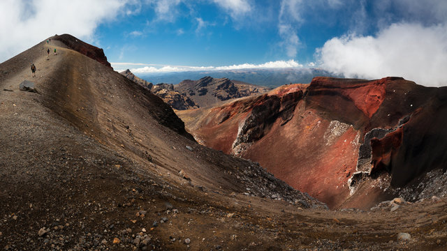 Hikers walking next to the Red Crater on the Tongariro Alpine Crossing famous hike in North Island of New Zealand