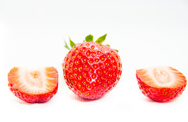 Whole and cut in half red strawberry and cut with leaves on white background