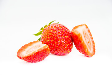 Whole and cut in half red strawberry and cut with leaves on white background