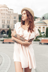 Naklejka premium Ourdoors Leisure. Girl standing on the city street crossed arms looking aside thoughtful