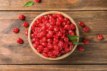 Bowl with tasty cherries on wooden background, top view. Dried fruits as healthy food