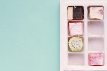 Traditional turkish delight  on blue background.  Arabic traditional dessert rahat lukum in a box. 