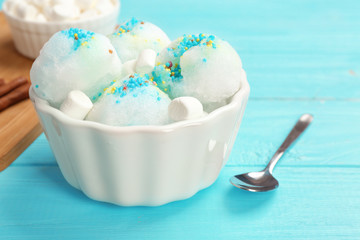 Bowl of tasty snow ice cream on color wooden table. Space for text